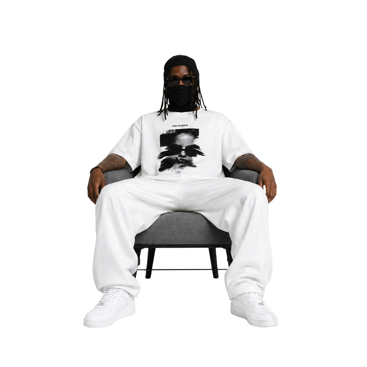 Seated figure in a DISNORDE masked-portrait t-shirt and white tracksuit