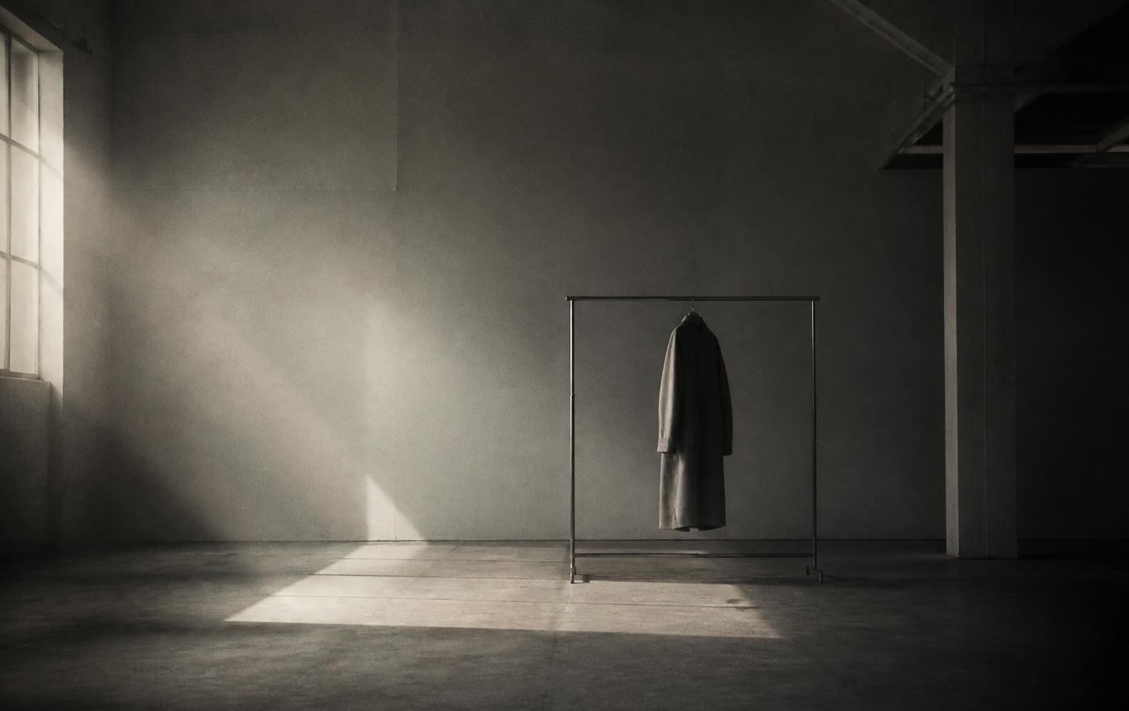 An empty studio at dusk with a single coat hanging on a rail